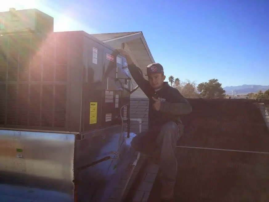 HVAC technician performing AC Tune-Up on a rooftop unit in Waxhaw